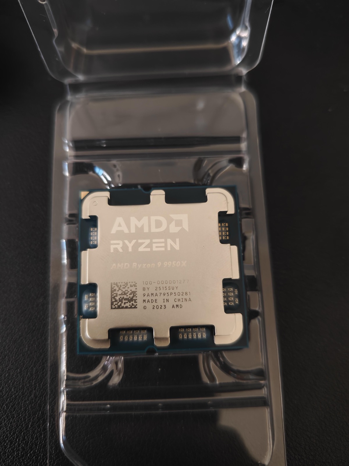 AMD Ryzen 9 9950X processor in clamshell packaging with AMD branding and serial number